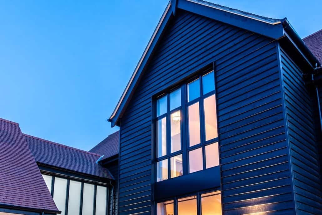 Corner bifold doors open on Essex barn new-build, night shot