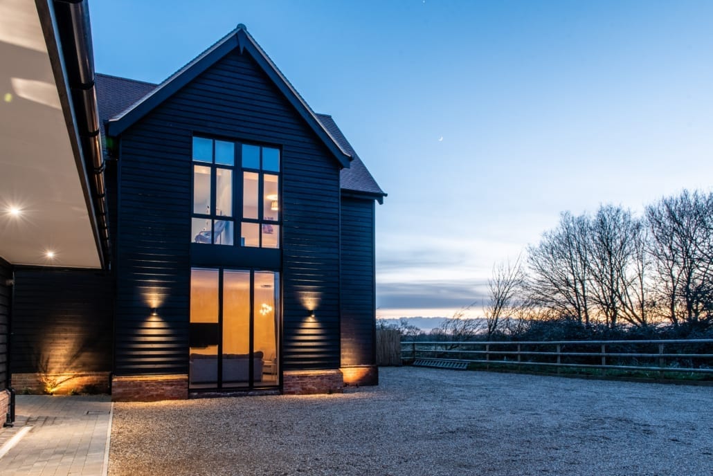 Spitfire aluminium front door with fingerprint entry on Essex barn at night