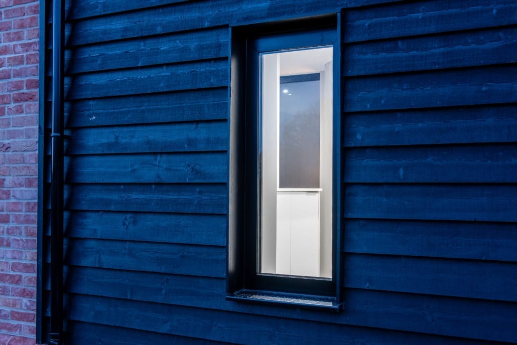 aïr bifold doors illuminated from inside on Essex barn at night