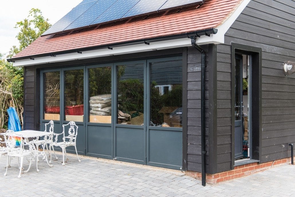 Five-leaf aluminium bifold doors fully open on coastal property rear