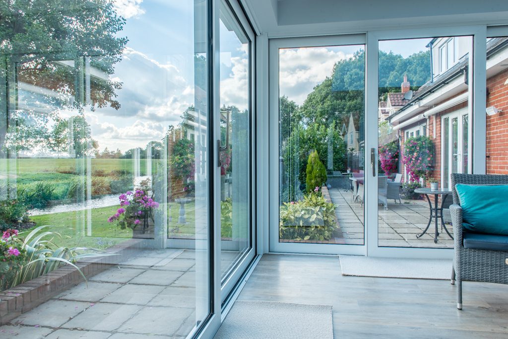 Sliding doors opening onto a riverside garden with River Stour views