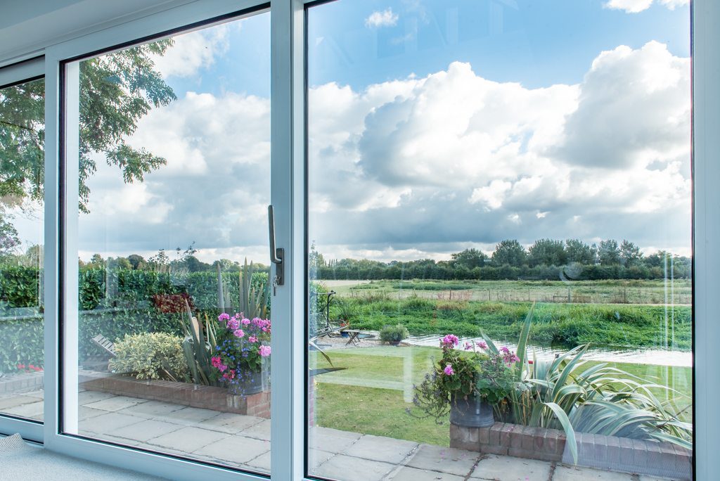 Interior view through large sliding doors framing the River Stour landscape