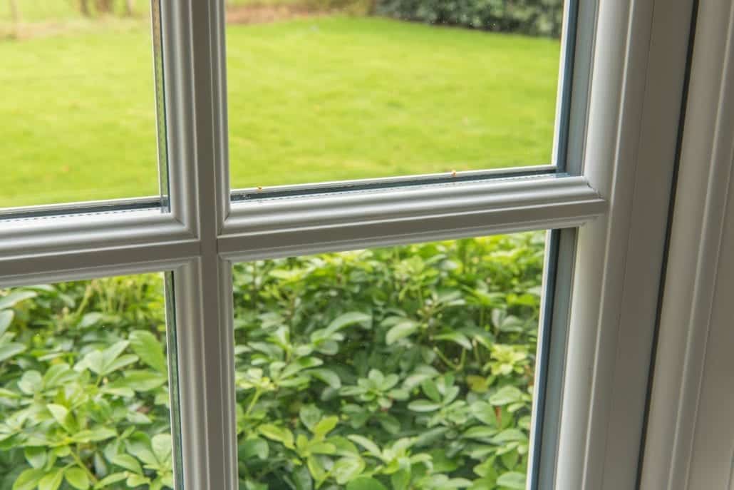 Traditional-profile uPVC stormproof windows on a soft red-brick country house
