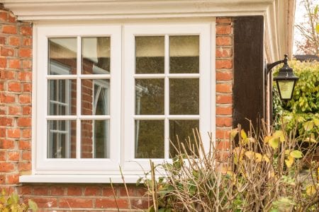 White uPVC stormproof casement window with Georgian bars in red brick