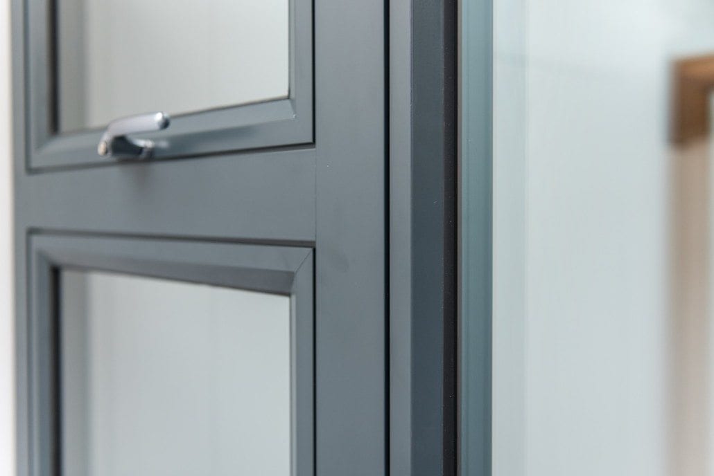 Close-up of a grey Origin aluminium door profile and handle in the showroom