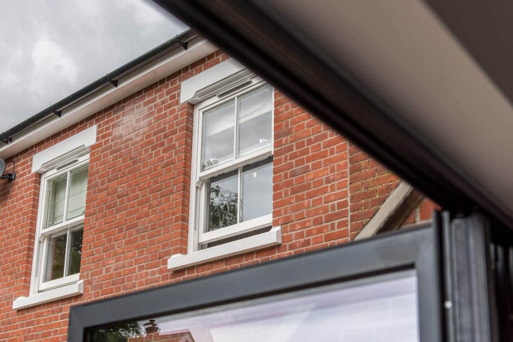 White Roseview sash windows on a red brick house seen from an open bifold