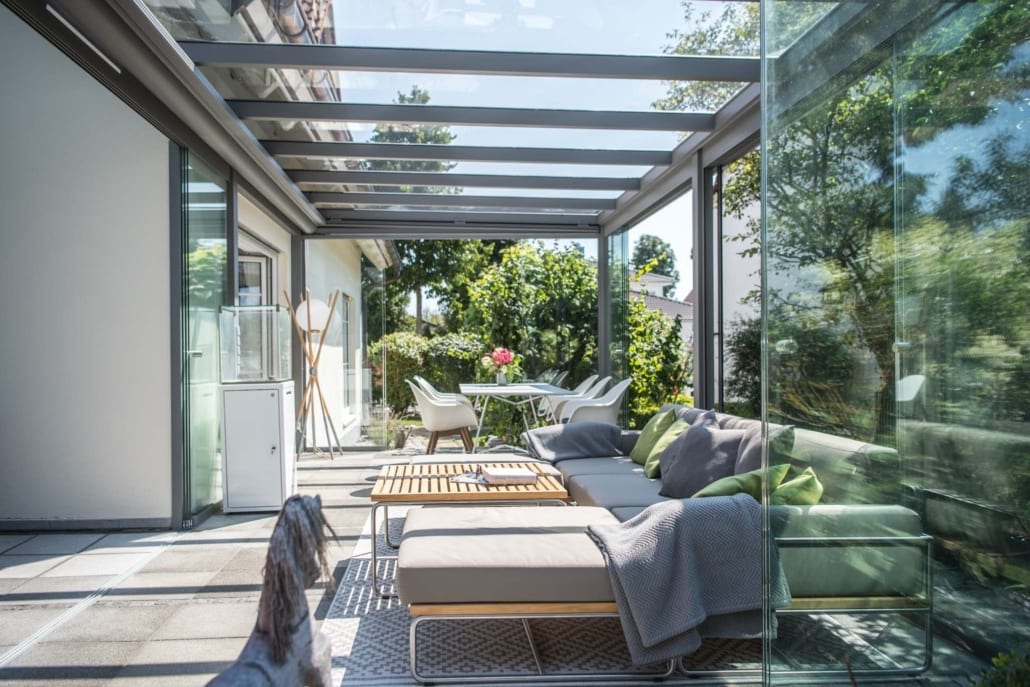 Inside a Sunparadise CUBO glass room with sliding glass walls onto the garden