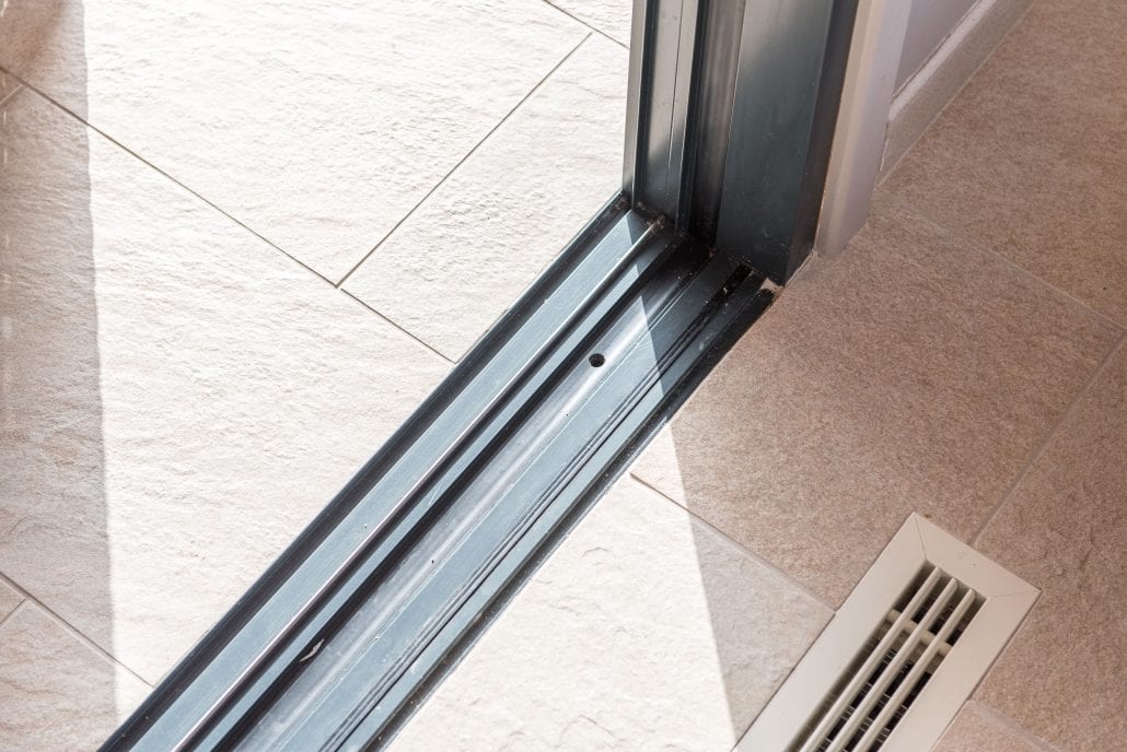 Close-up of a flush sliding door threshold onto porcelain paving