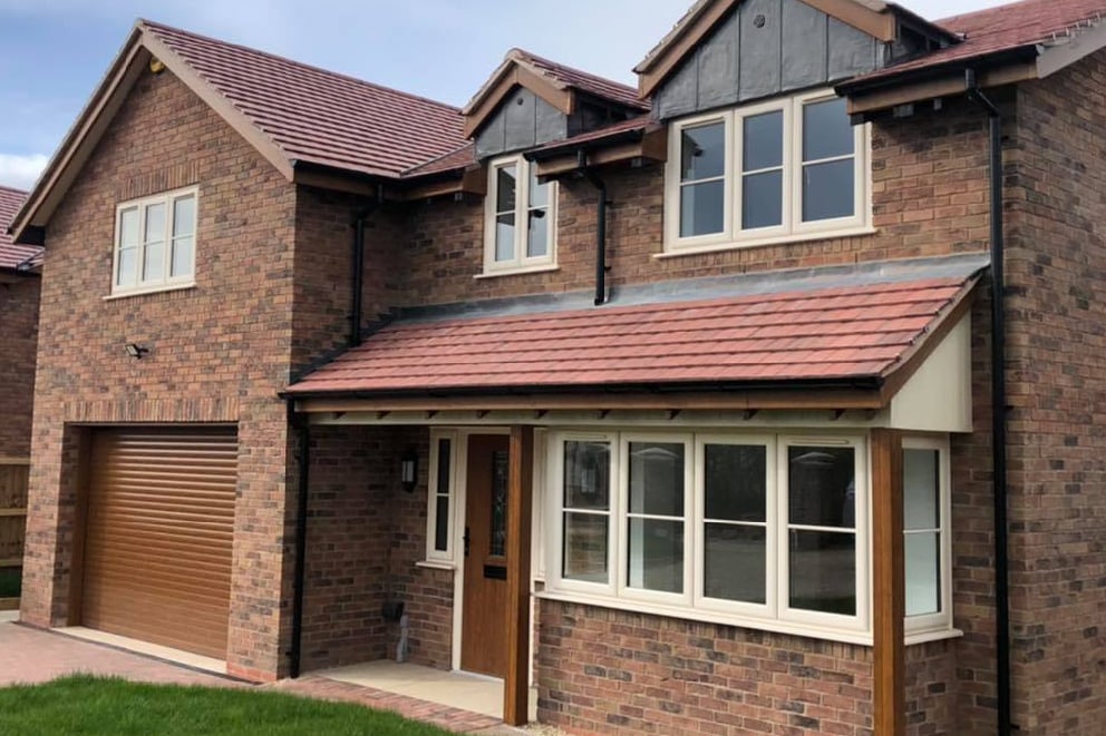 Cream casement windows and dormers on a brick and weatherboard house
