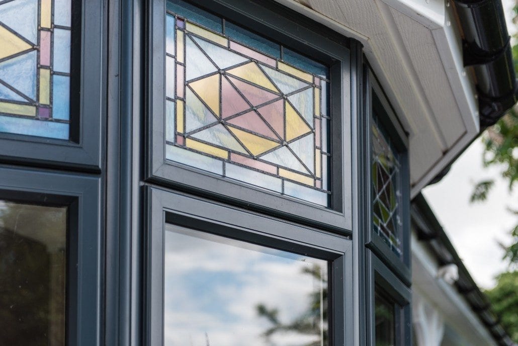 Triangular aluminium apex window in a brick and clad gable