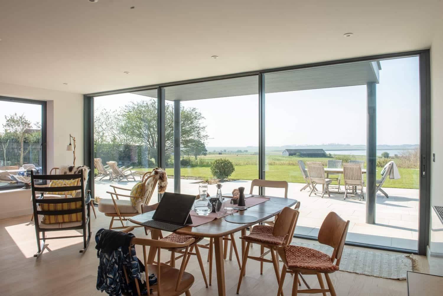 Open-plan dining room with Origin and Smarts aluminium glazing opening to countryside
