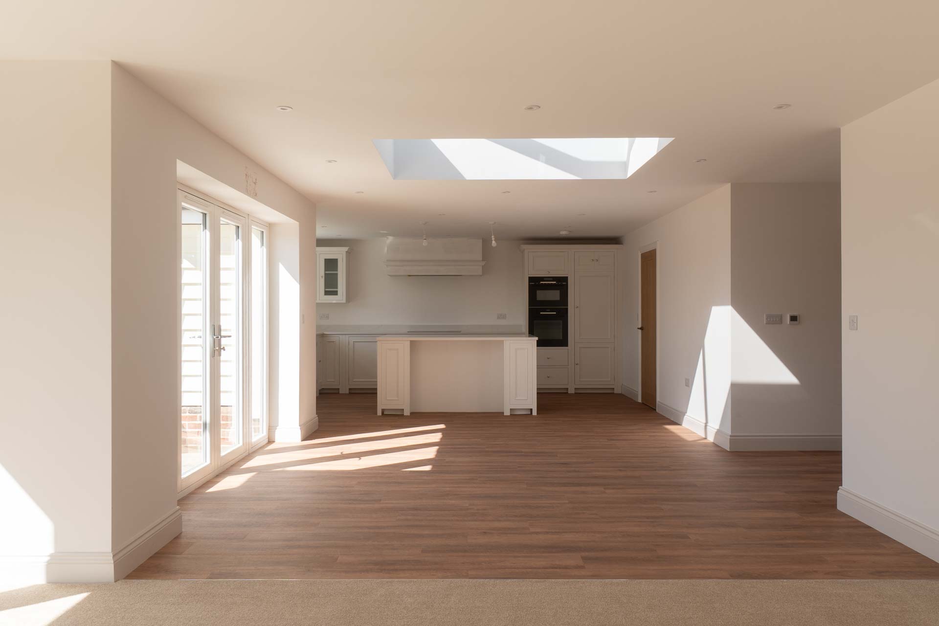 Open-plan kitchen and dining space with French doors and a roof lantern overhead