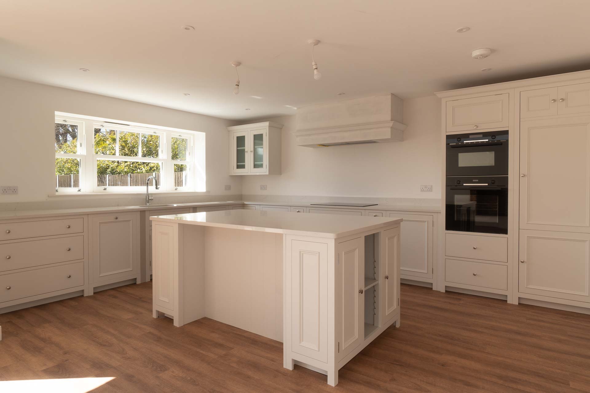 Shaker kitchen with a white uPVC vertical sliding window above the sink