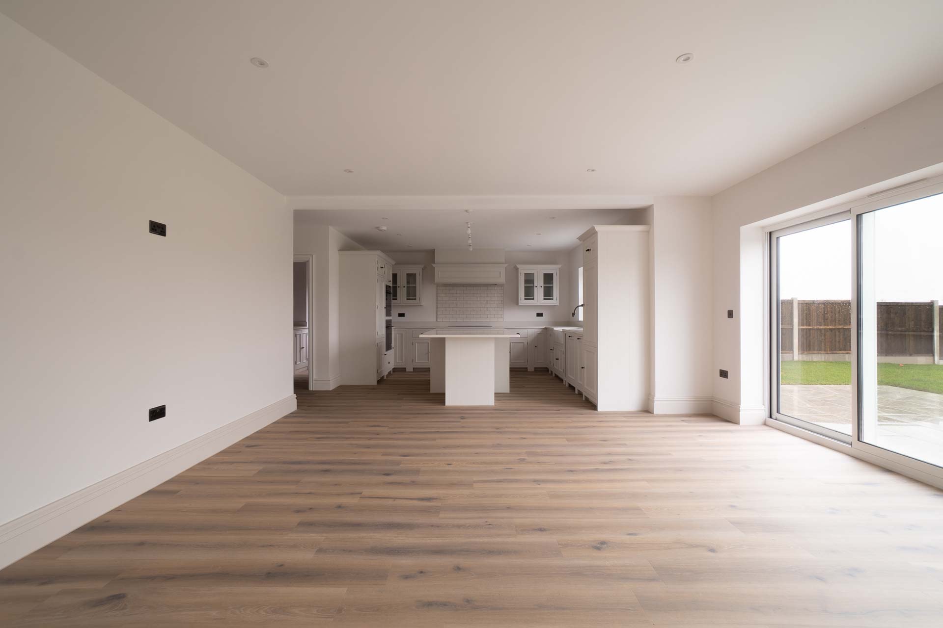 Open-plan kitchen and living space with a full-height aluminium sliding patio door onto the garden