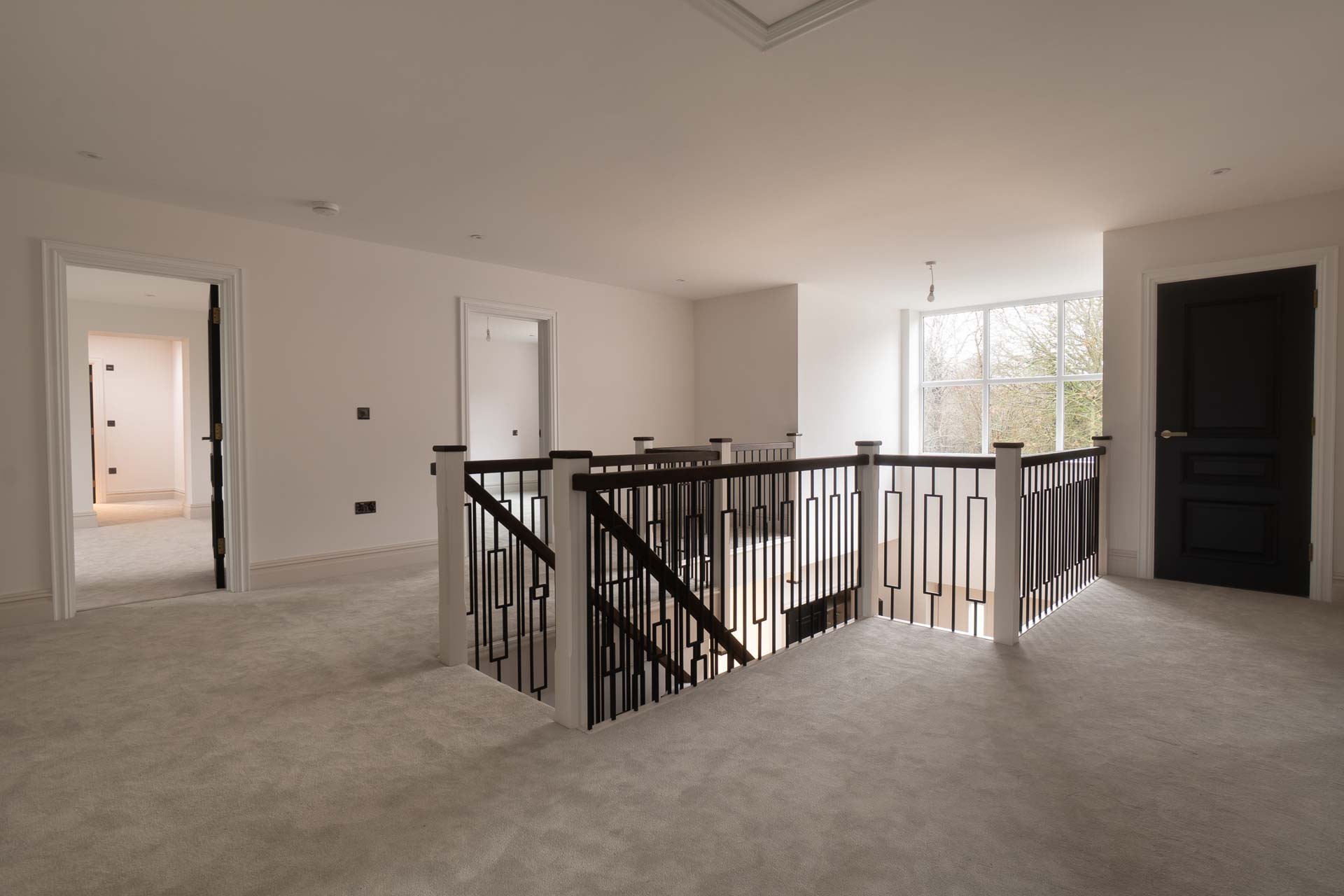 Galleried landing lit by a tall uPVC vertical sliding window with astragal bars