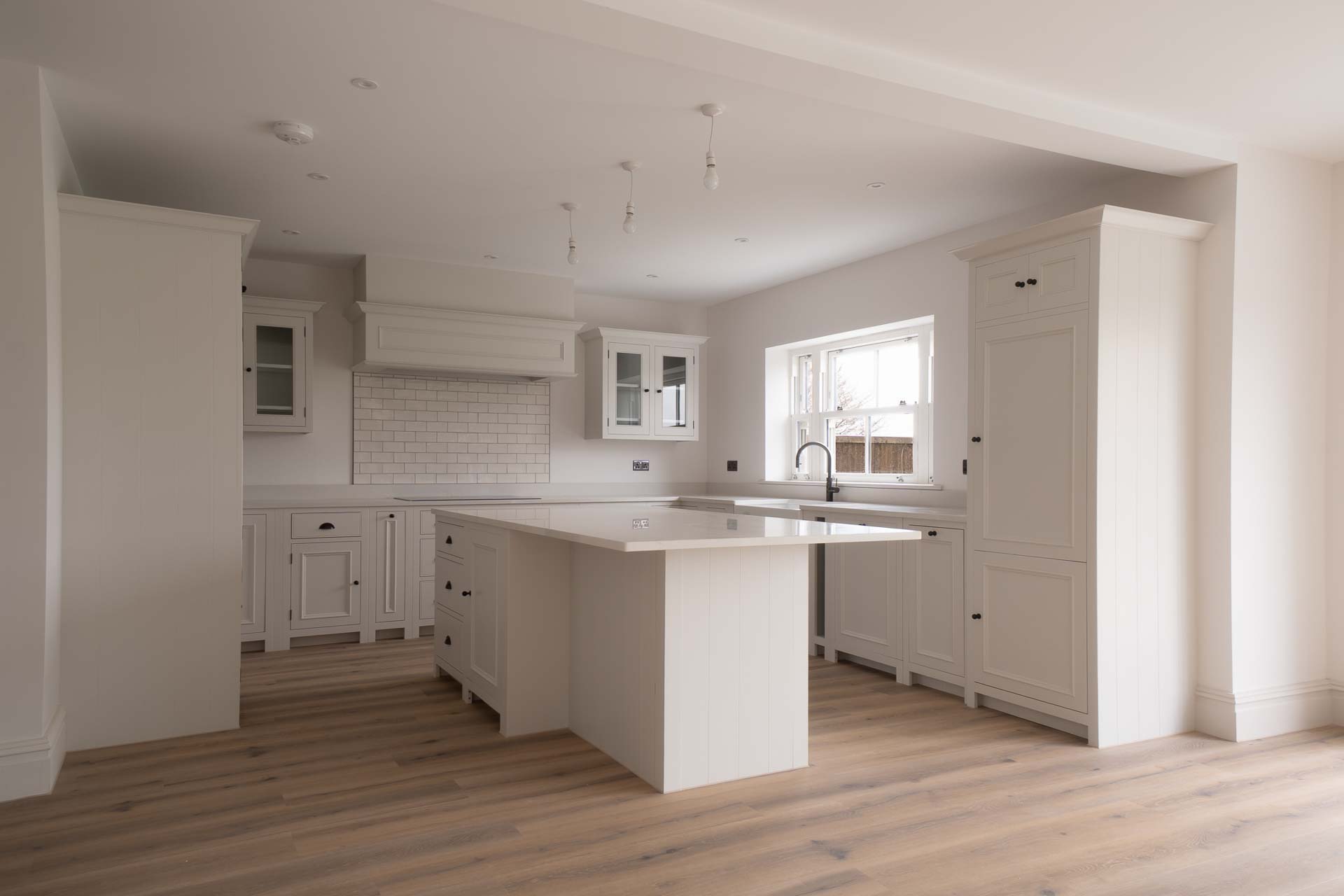 Shaker kitchen with a white uPVC vertical sliding window above the sink
