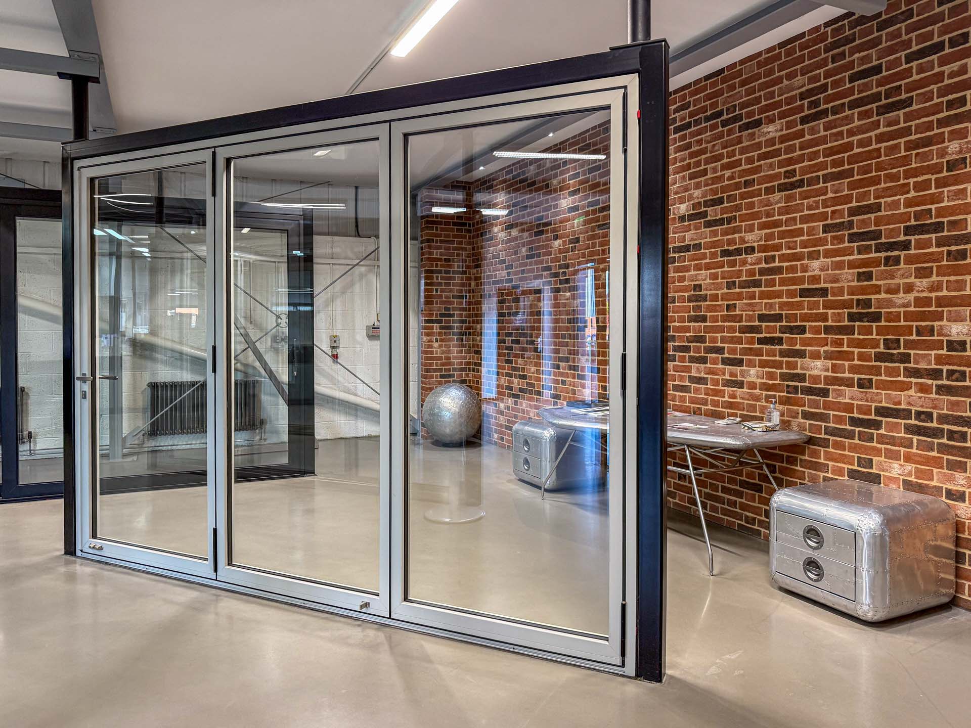 A three-panel aluminium bifold door on display in the Windows Etc showroom