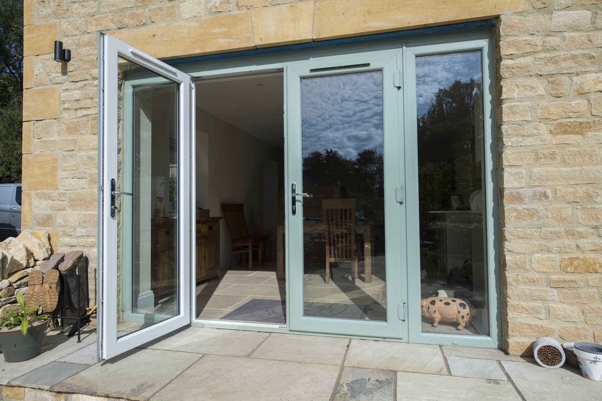 Deceuninck Heritage 2800 French doors in Chartwell Green standing open onto a stone patio