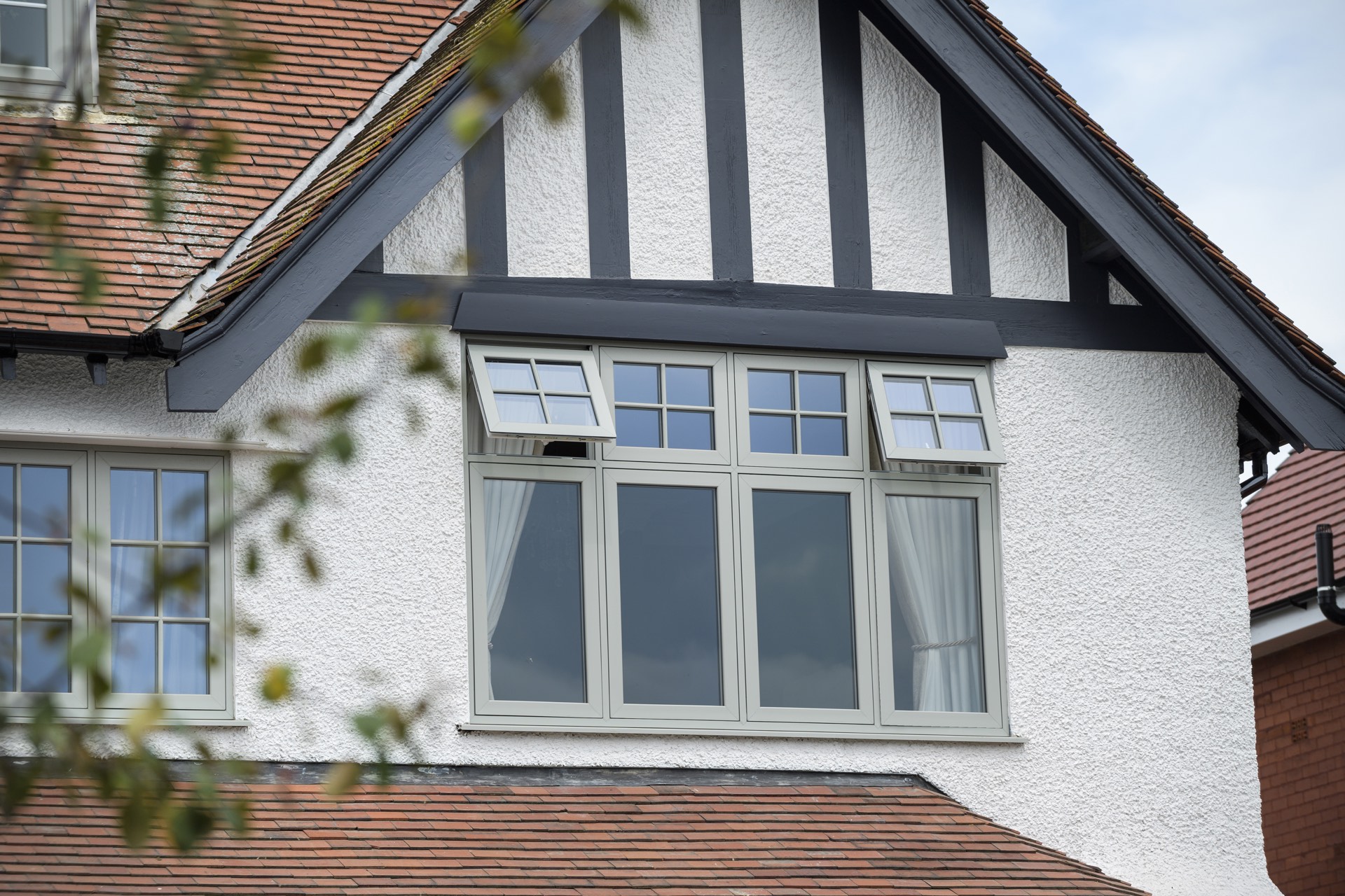 Deceuninck Heritage Flush casement windows with Georgian bars in a tiled gable, top-hung night vents open