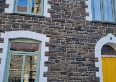 Deceuninck Traditional 2500 chamfered casement windows in pale green on a stone terraced house