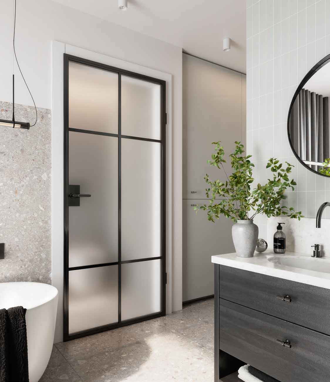 Black steel door with frosted glass and a grid of glazing bars in a bathroom